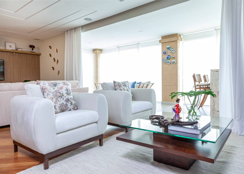 Saiba como adotar a estética floral na decoração da casa. Projeto de Cristiane Schiavoni Arquitetura. Na foto, sala com almofadas floridas.