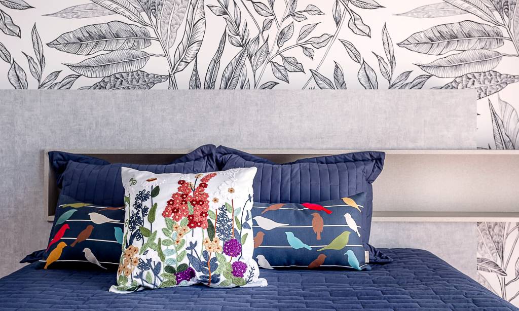 Saiba como adotar a estética floral na decoração da casa. Projeto de Cristiane Schiavoni Arquitetura. Na foto, quarto com papel de parede e almofadas floridas.
