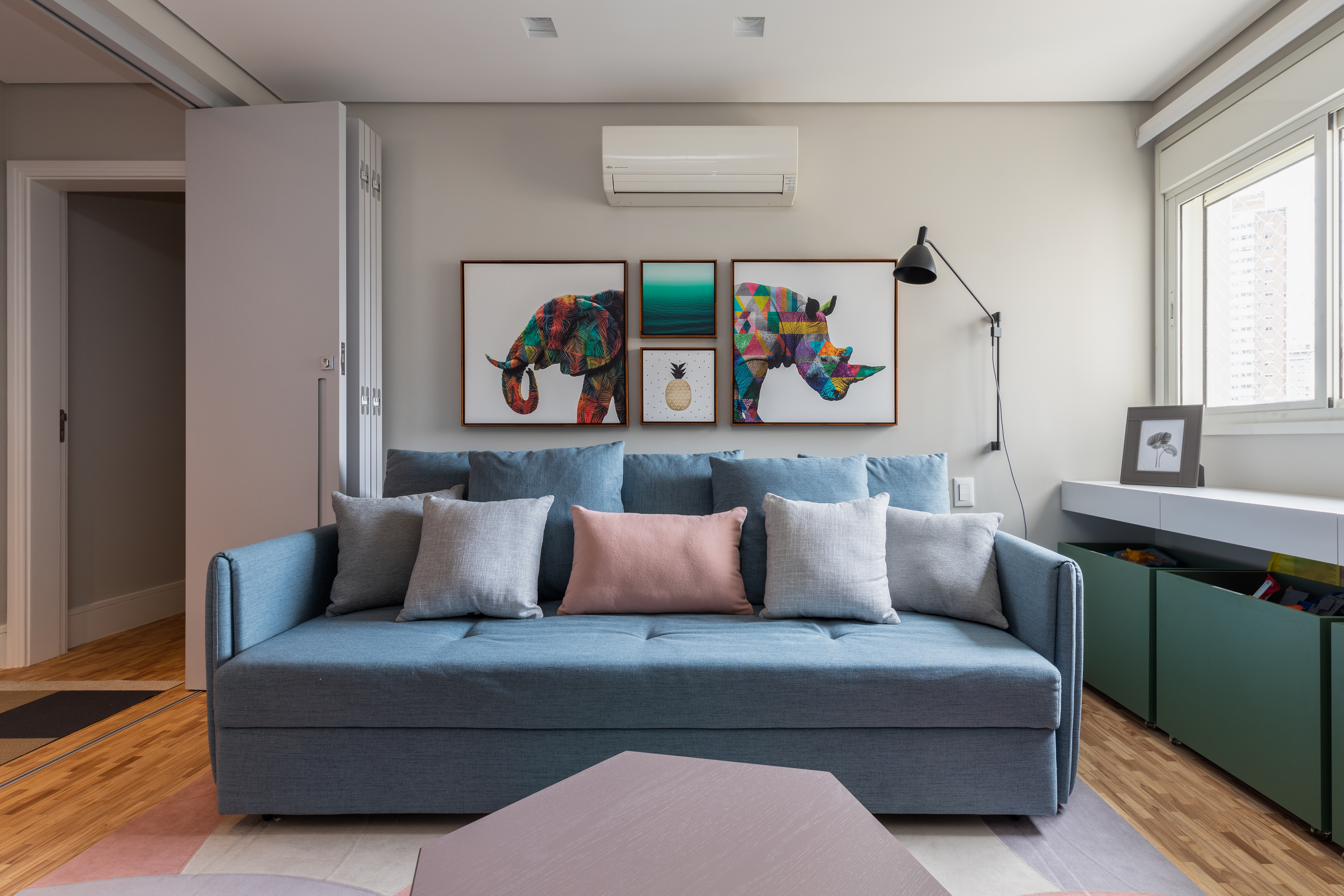 Neste apê, sala de TV com sofá cama elétrico é brinquedoteca. Projeto de CADDA Arquitetura.