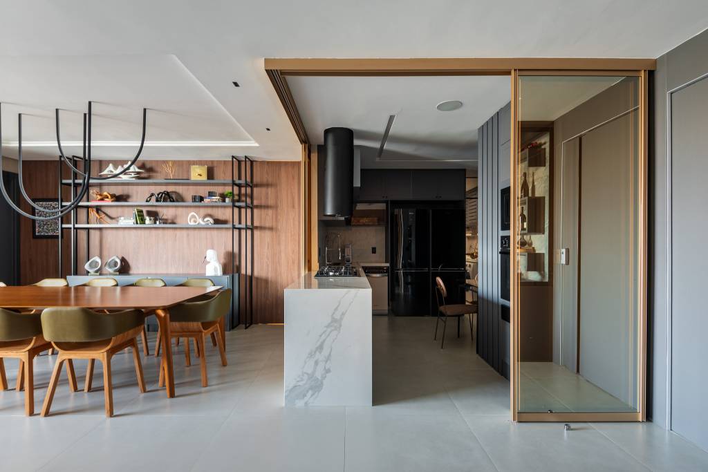 Sala de vinhos elegante tem estante personalizada, poltronas de couro e uma vitrola. Projeto de Grace Dantas Arquitetura.