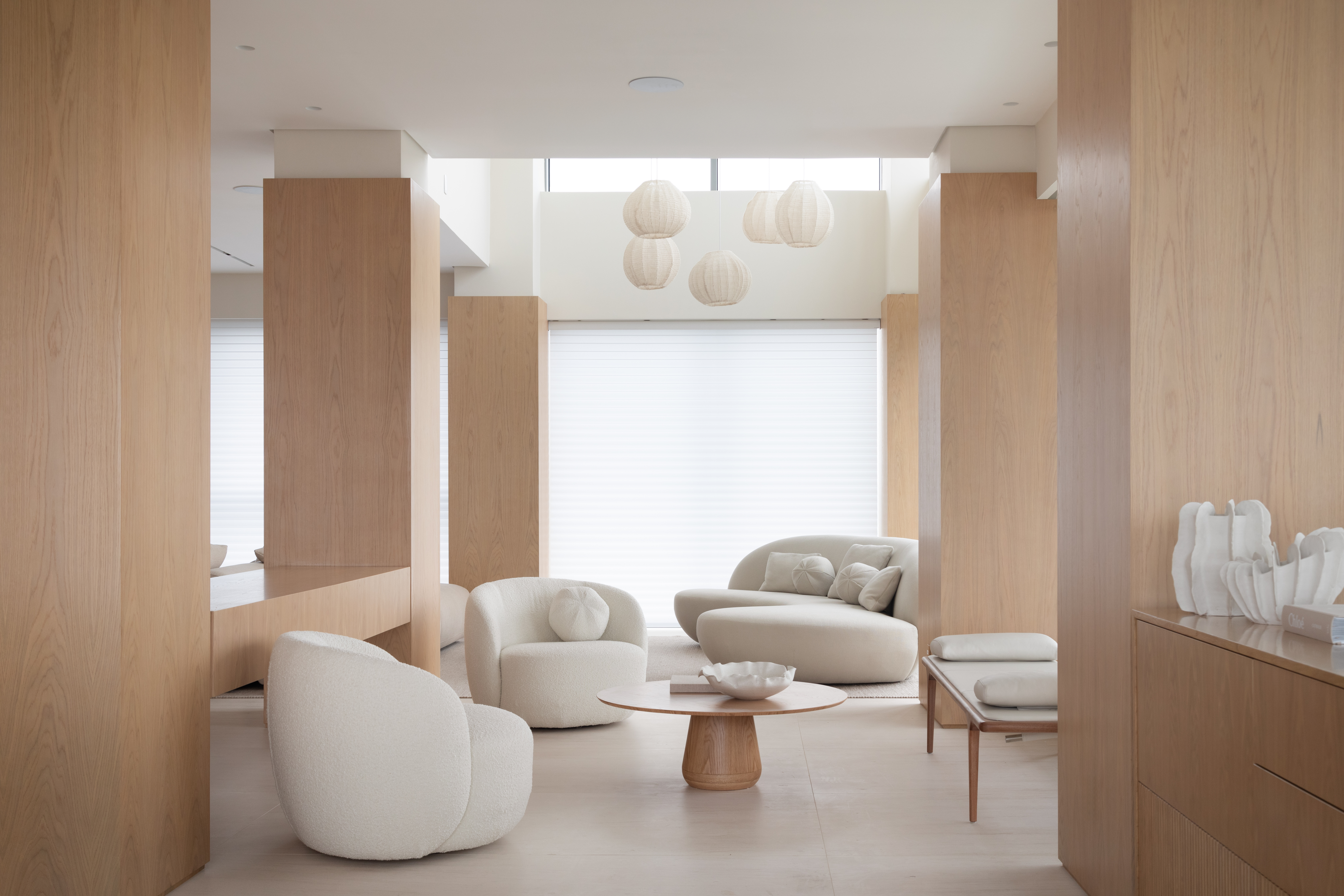 Apartamento minimalista tem móveis soltos e ilha em Dekton na cozinha