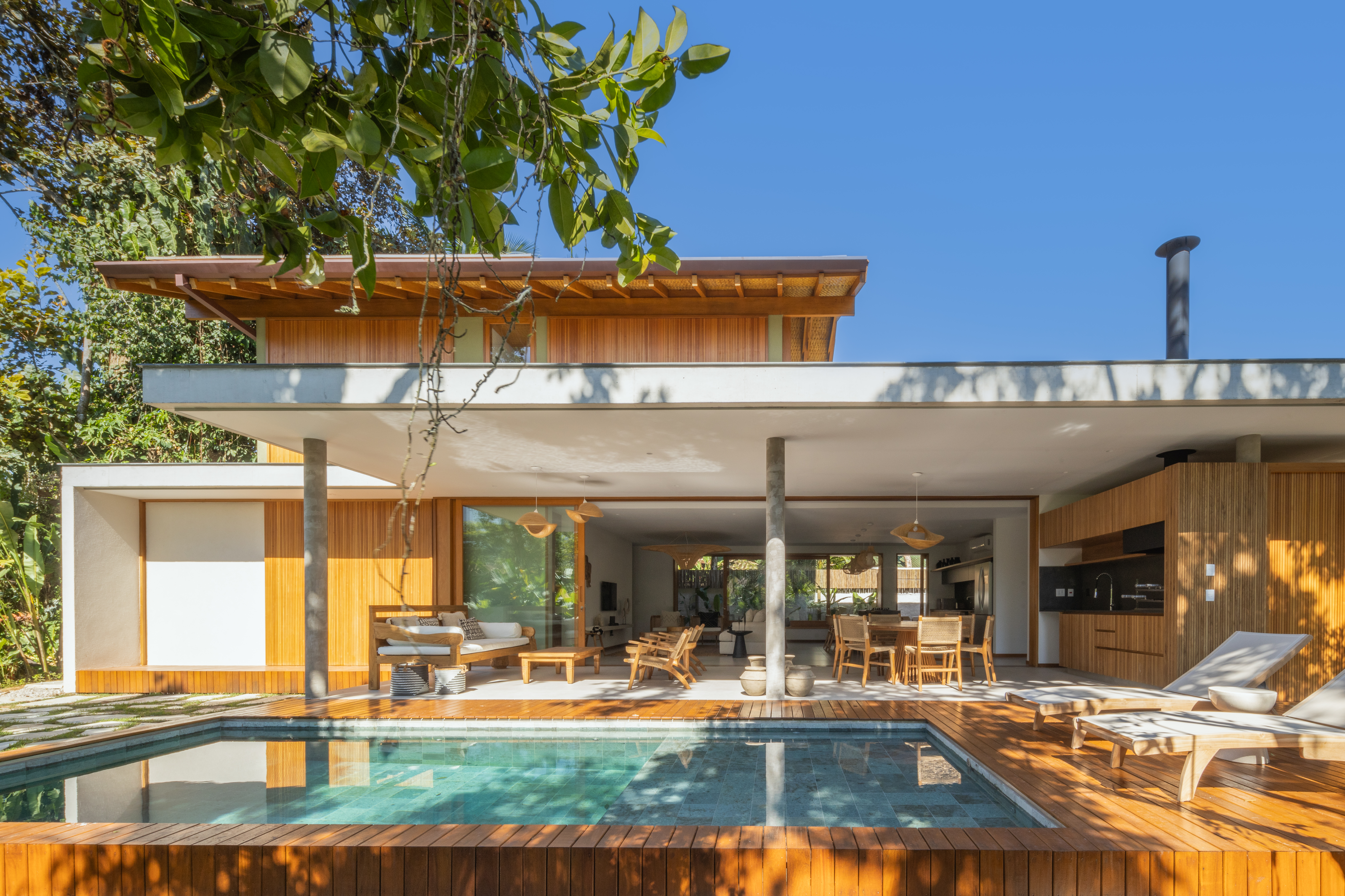 Linda casa com em Ubatuba tem materiais leves e janela-banco entre cozinha e jantar