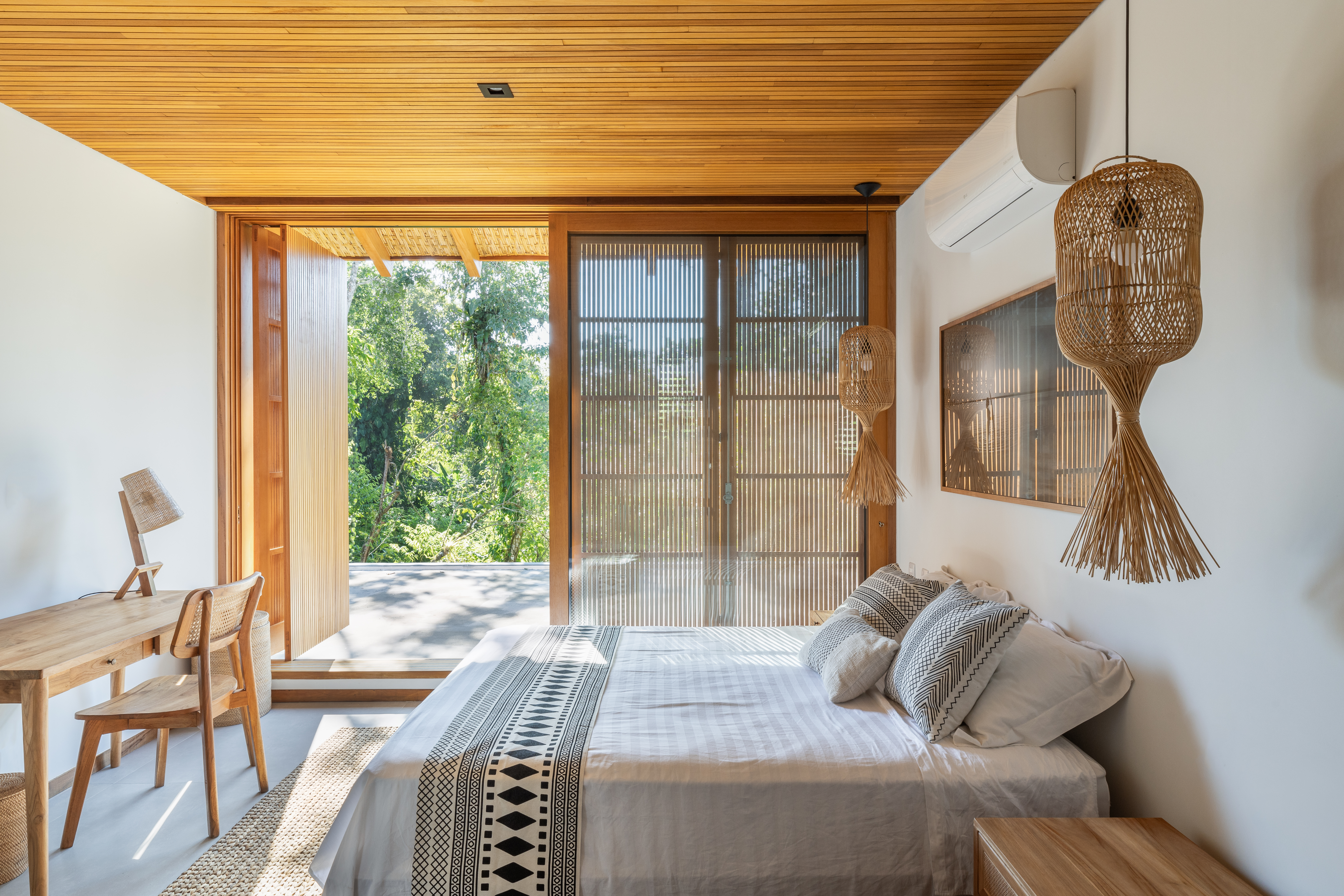 Linda casa com em Ubatuba tem materiais leves e janela-banco entre cozinha e jantar. Projeto de Pitta Arquitetura.