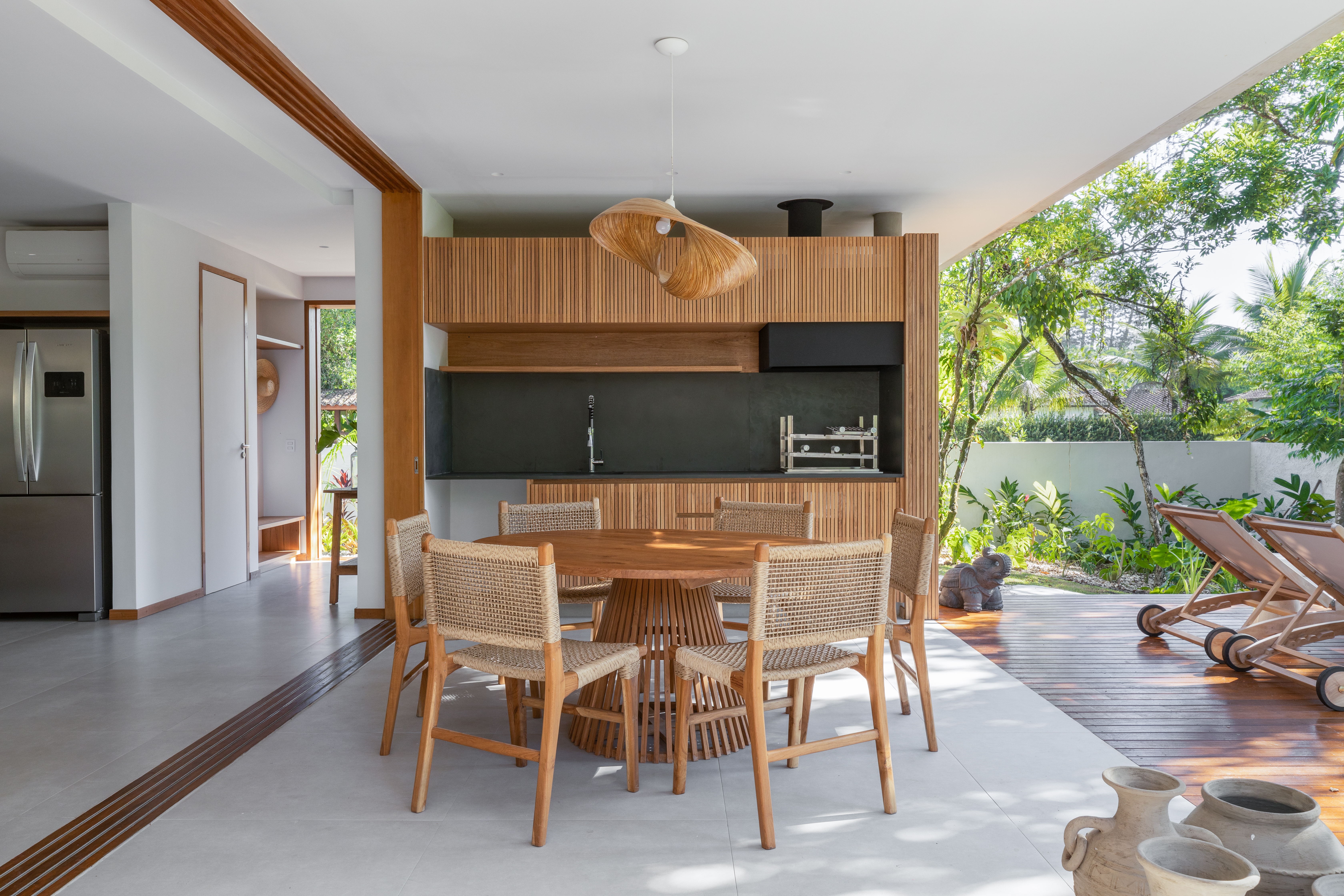 Linda casa com em Ubatuba tem materiais leves e janela-banco entre cozinha e jantar. Projeto de Pitta Arquitetura.