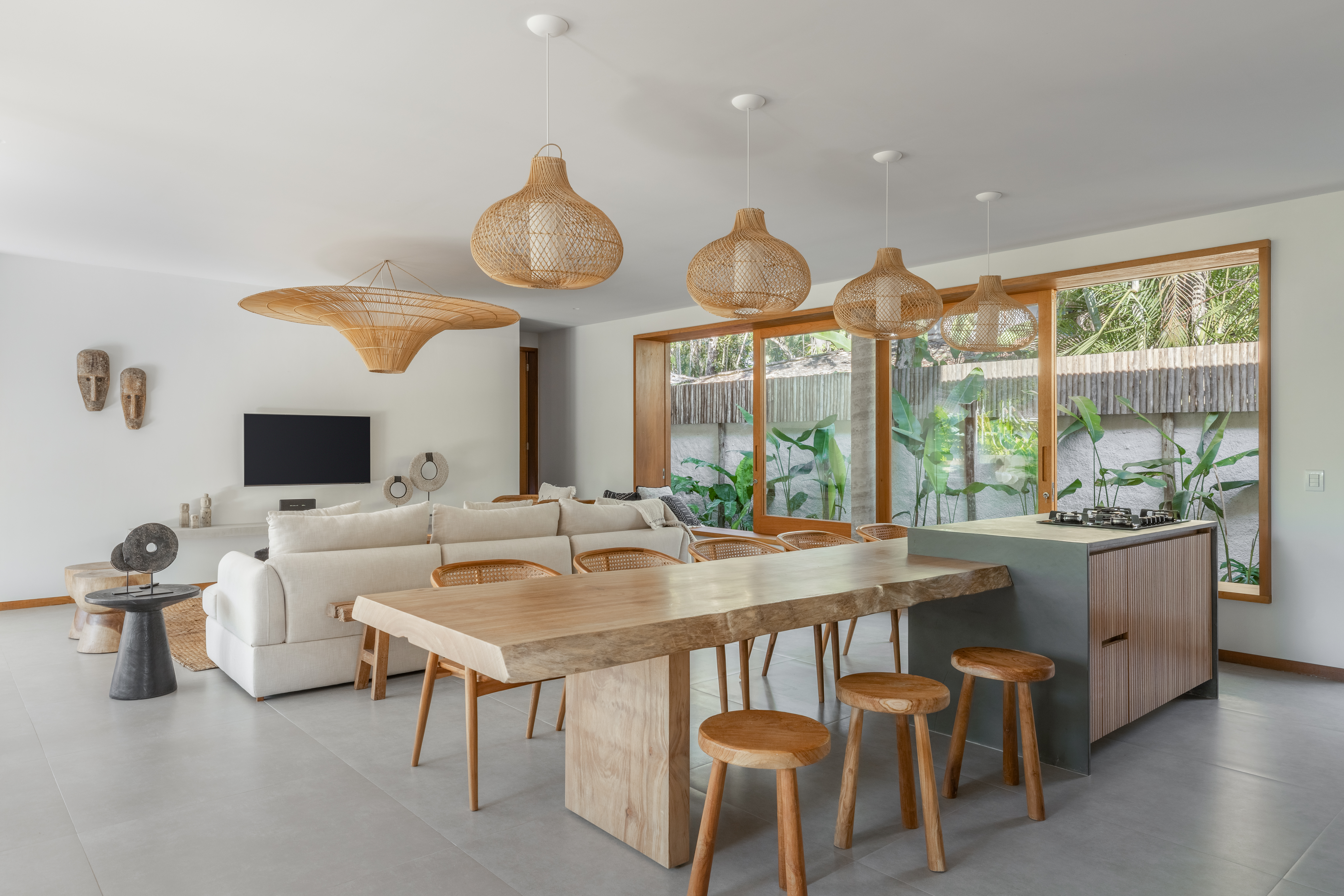 Linda casa com em Ubatuba tem materiais leves e janela-banco entre cozinha e jantar. Projeto de Pitta Arquitetura.