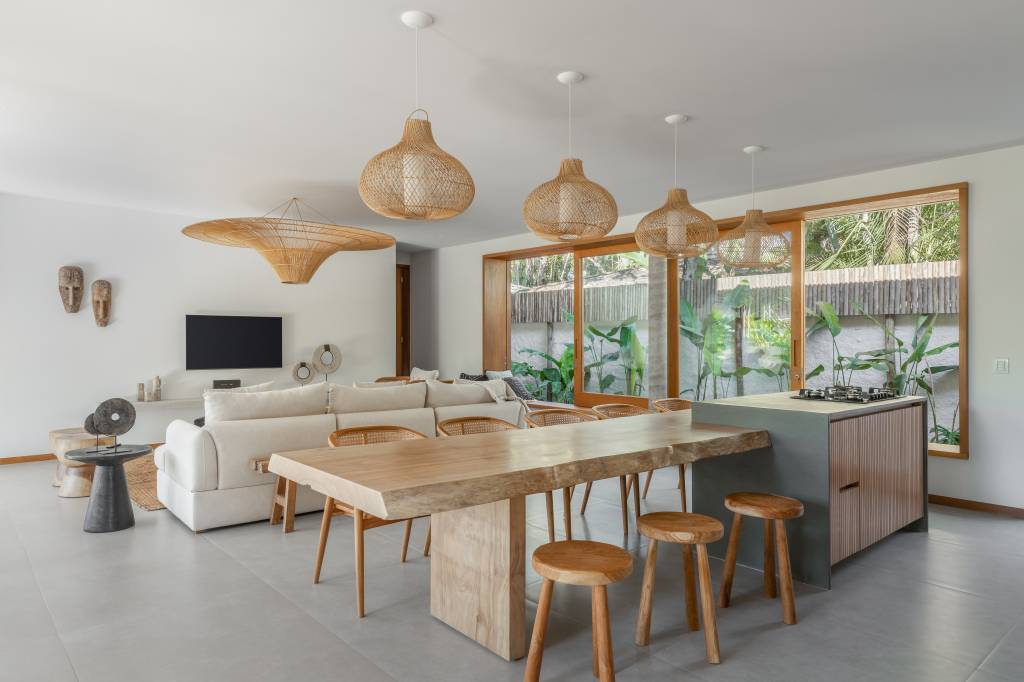 Linda casa com em Ubatuba tem materiais leves e janela-banco entre cozinha e jantar. Projeto de Pitta Arquitetura.