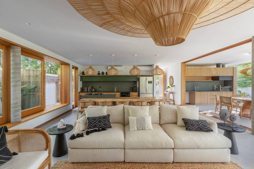 Linda casa com em Ubatuba tem materiais leves e janela-banco entre cozinha e jantar. Projeto de Pitta Arquitetura.