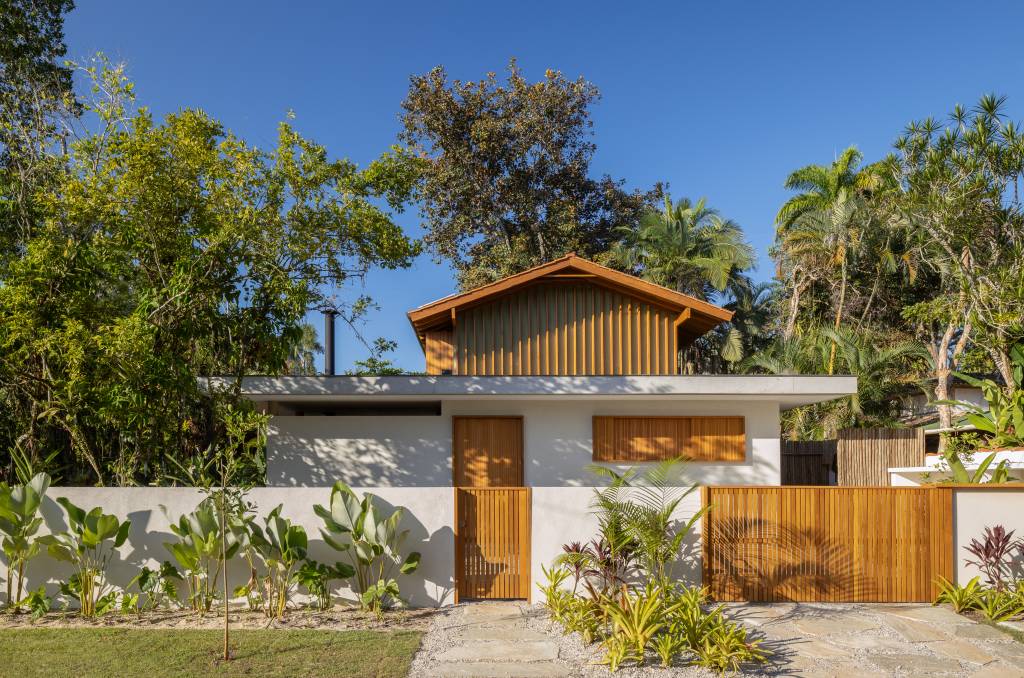 Linda casa com em Ubatuba tem materiais leves e janela-banco entre cozinha e jantar. Projeto de Pitta Arquitetura.