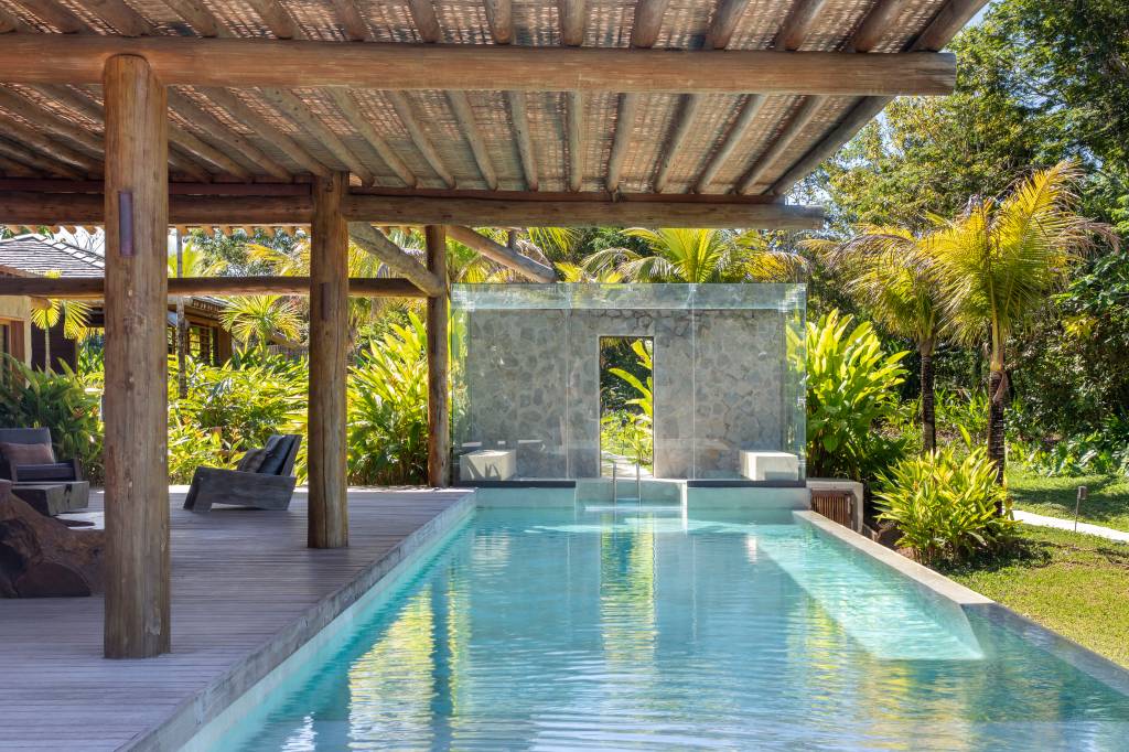 Casa de praia deslumbrante em Trancoso tem módulos conectados por deques de madeira. Projeto de DB Arquitetos.