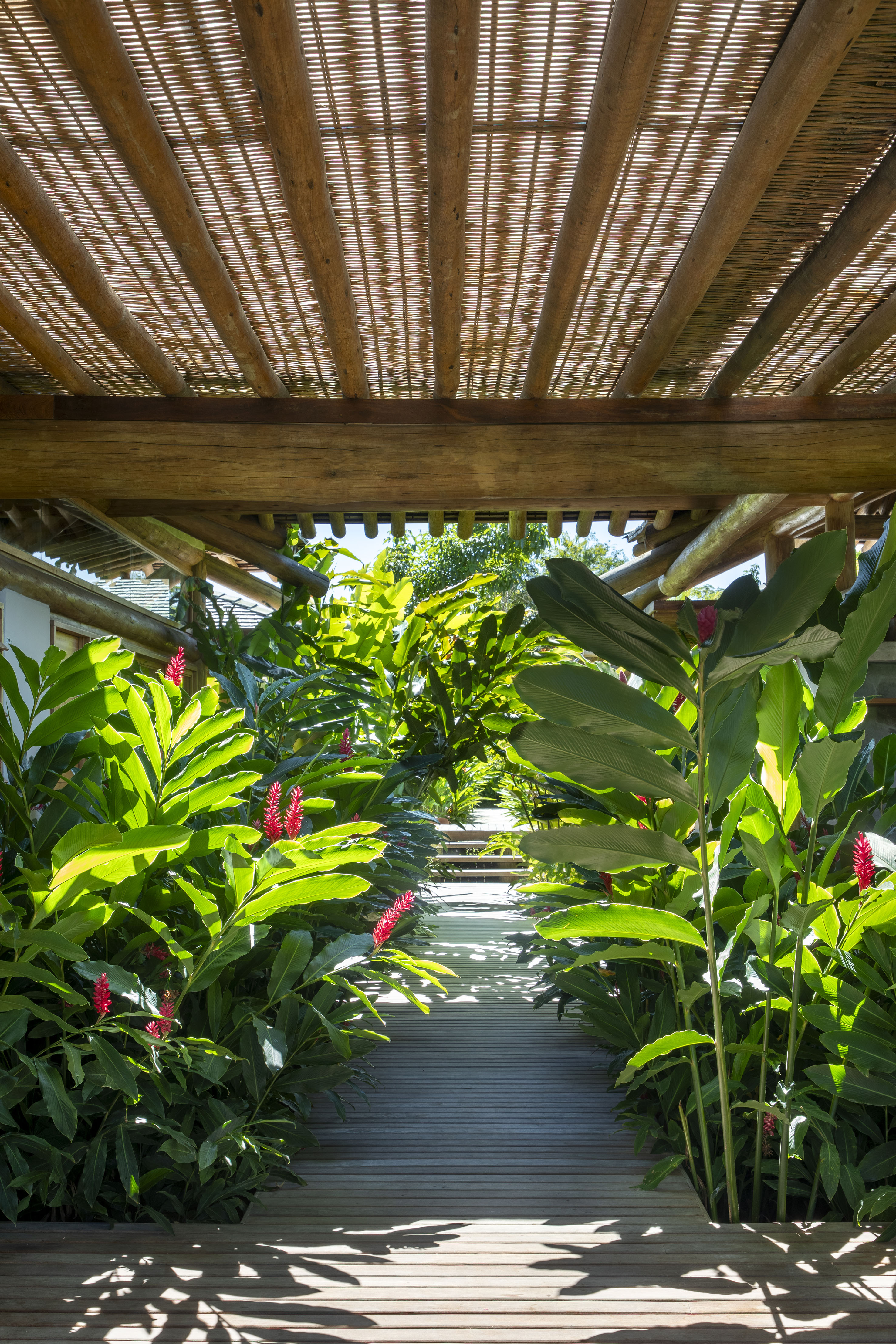 Casa de praia deslumbrante em Trancoso tem módulos conectados por deques de madeira. Projeto de DB Arquitetos.