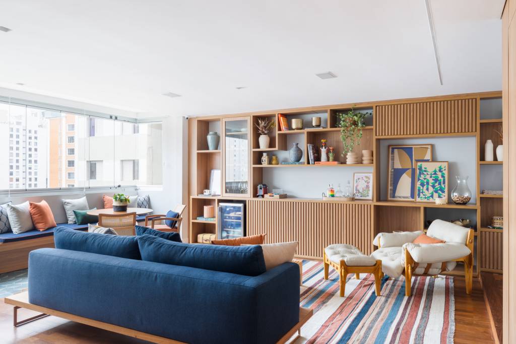 Ladrilhos e tacos se misturam na varanda integrada deste apê com banco e jardineira. Projeto de MAJ Arquitetura.