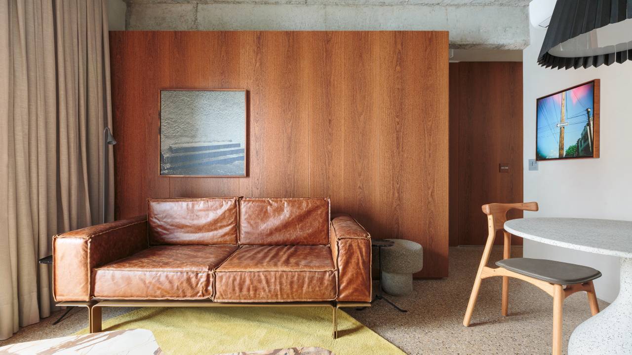 Marcenaria de madeira sucupira é destaque em apartamento compacto com vibe industrial. Projeto de Pro.a Arquitetos.