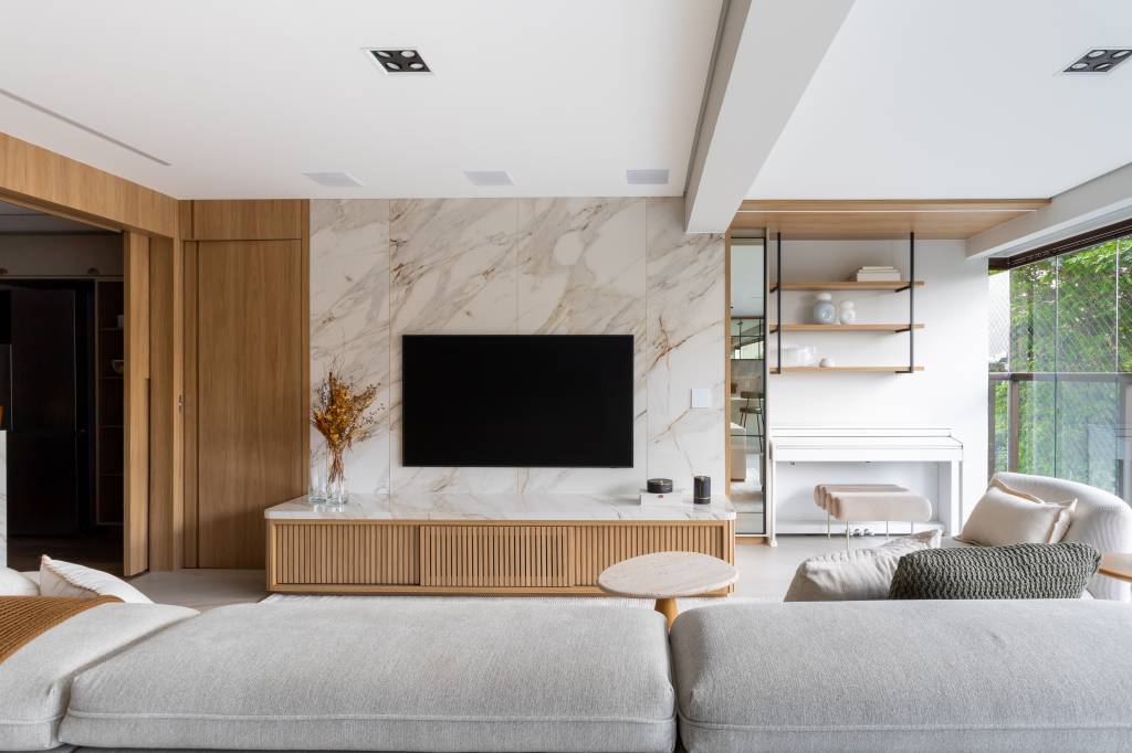 Revestimentos marmorizados e cristaleiras com vidro reflecta dão ar sofisticado à apê clássico