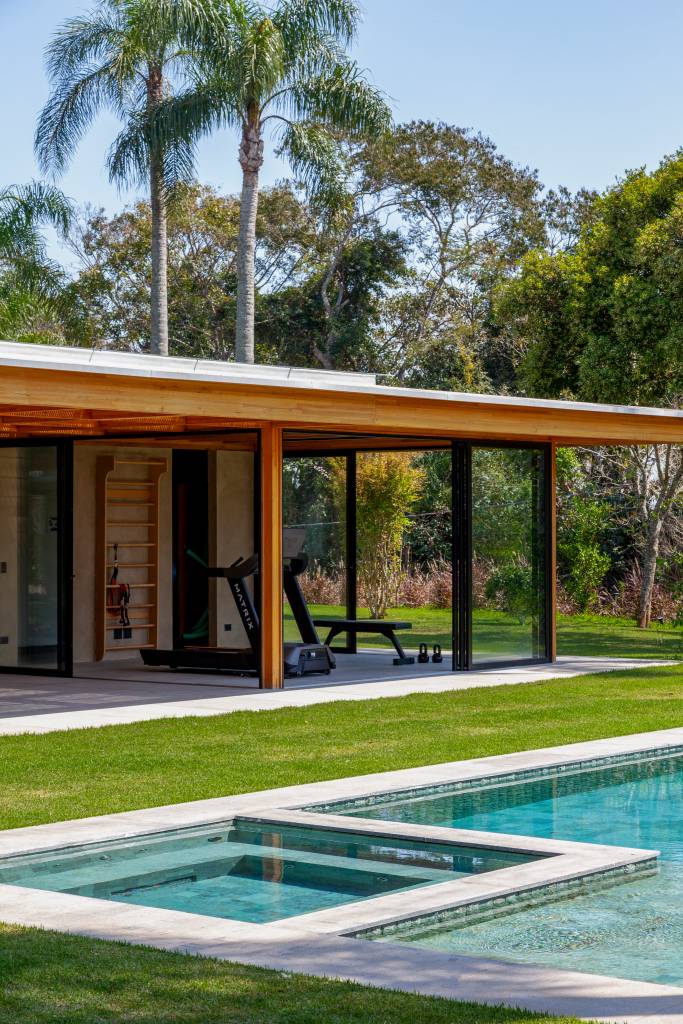 Suíte principal, academia e sauna são interligadas por pergolado nesta casa de campo. Projeto de Sandra Sayeg.