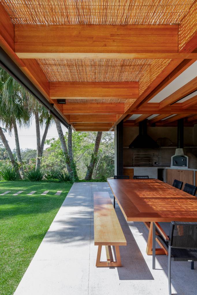 Suíte principal, academia e sauna são interligadas por pergolado nesta casa de campo. Projeto de Sandra Sayeg.