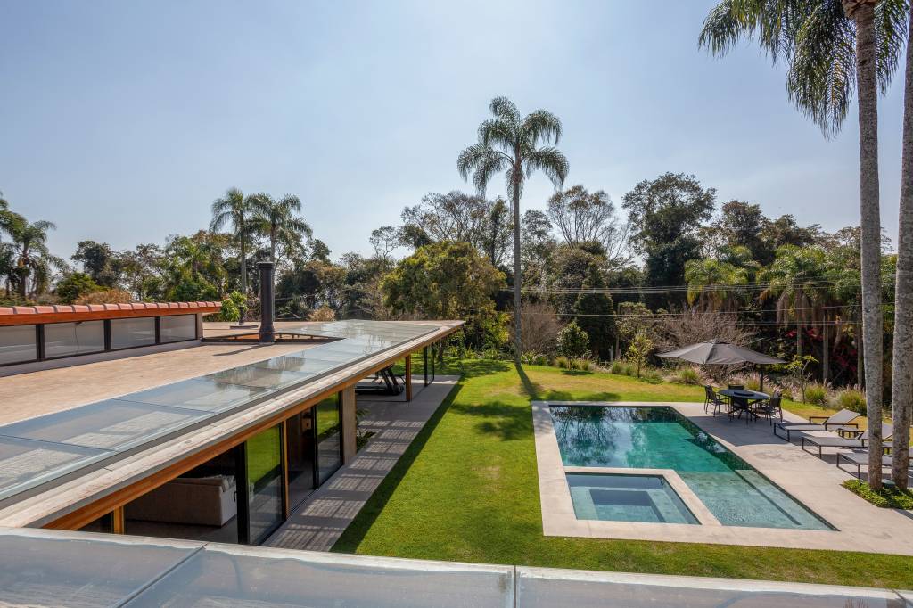 Suíte principal, academia e sauna são interligadas por pergolado nesta casa de campo. Projeto de Sandra Sayeg.