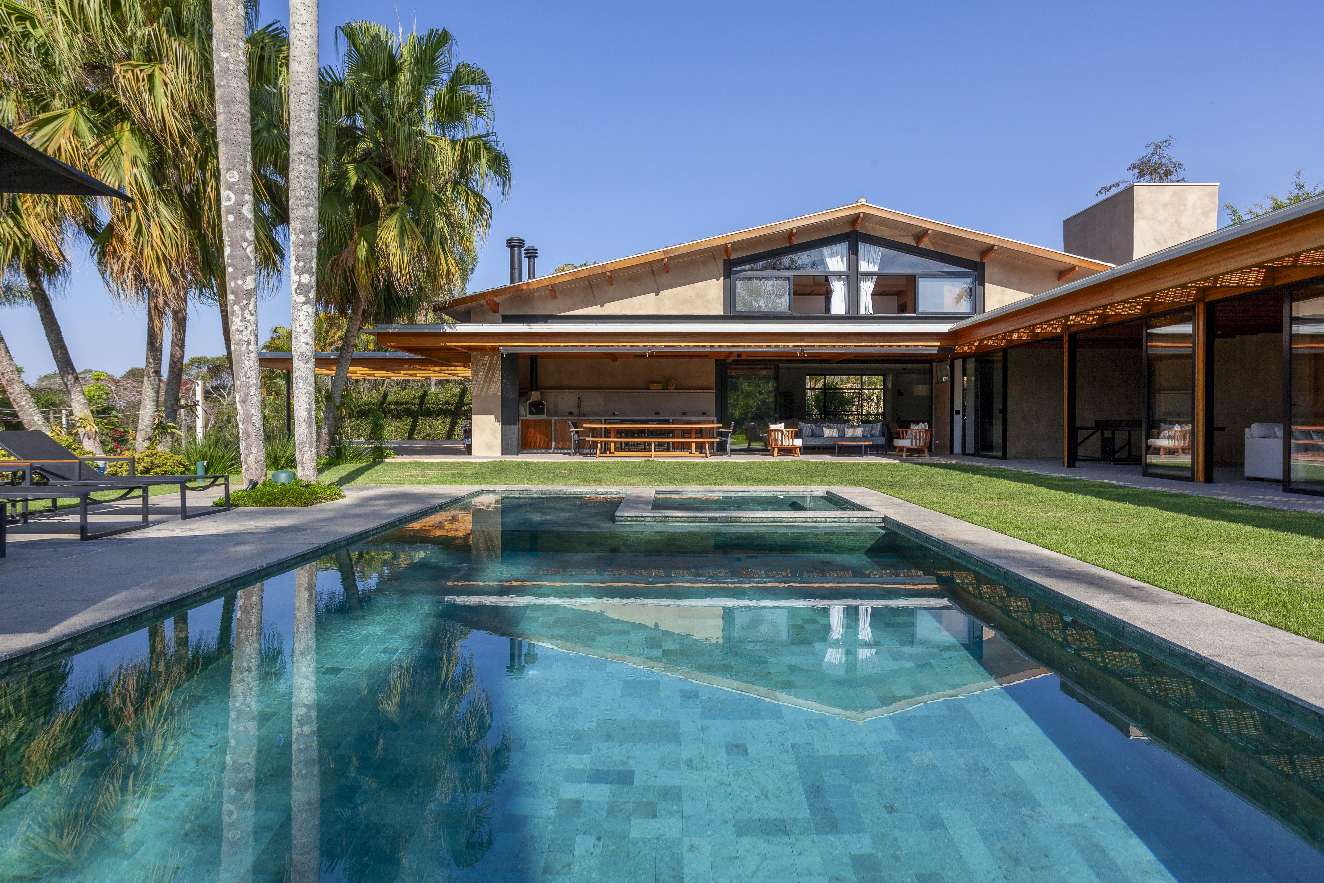 Suíte principal, academia e sauna são interligadas por pergolado nesta casa de campo