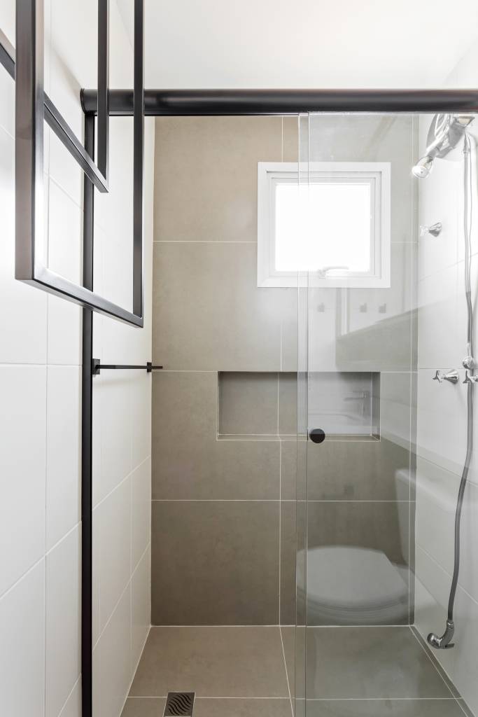 Toalheiros em serralheria descem do teto em banheiro e lavabo deste apartamento. Projeto de RMV Interiores.