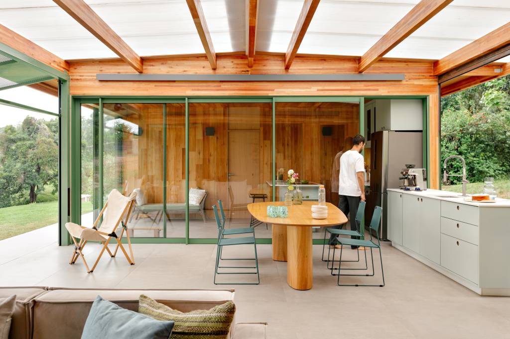 Varanda com telhas transparentes fica entre blocos de casa em CLT montada em 1 semana