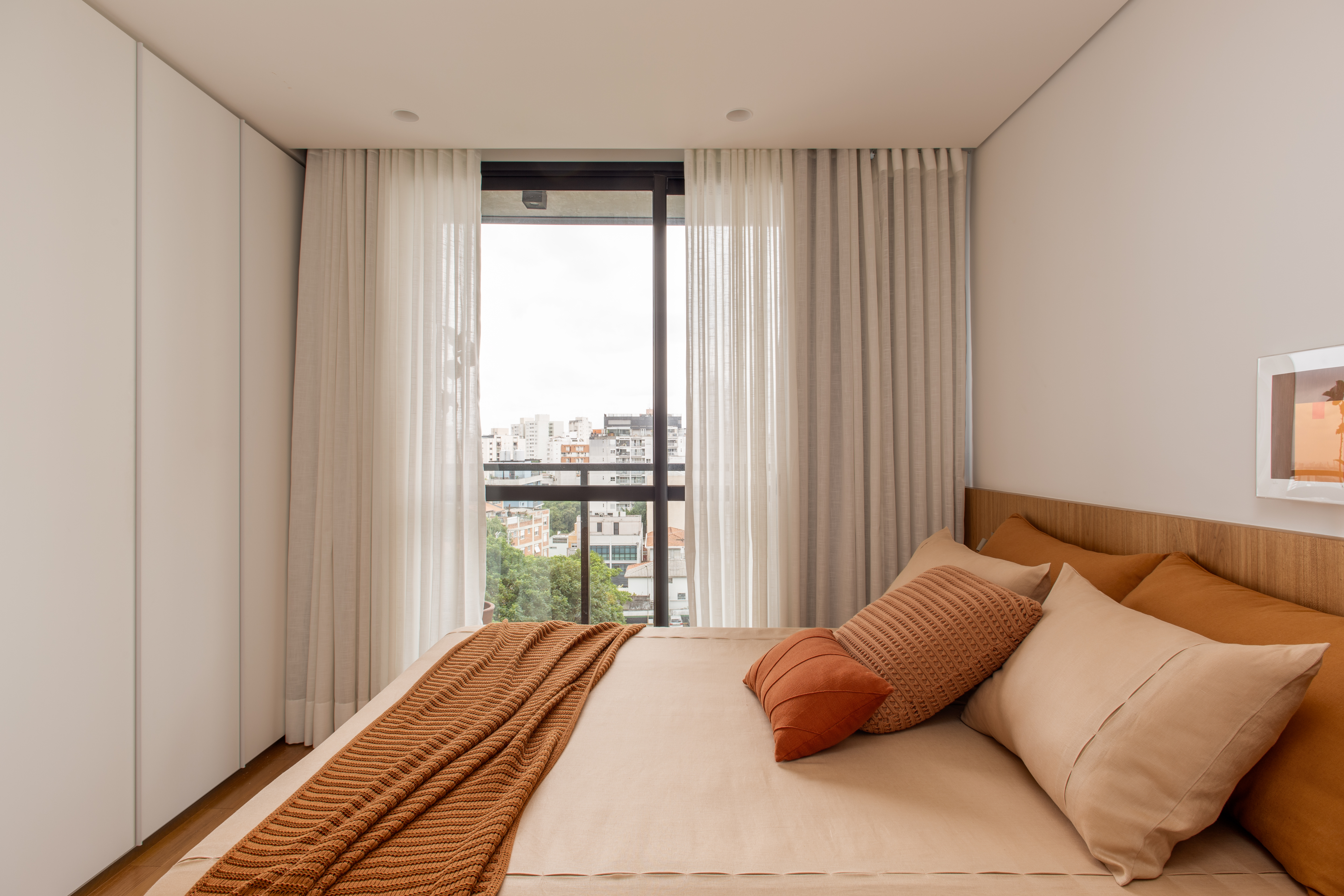 Apê ganha sofá pequeno embutido na marcenaria para contemplar vista. Projeto de W. Arquitetura.