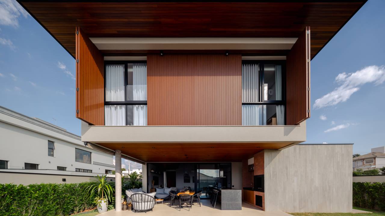 Brises e ripas em metal e concreto garantem privacidade e transparência nesta casa. Taguá Arquitetura.