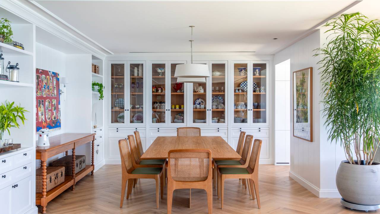 Cristaleira piso-teto dá charme a sala de jantar deste apê de frente para o mar. Projeto de Carolina Gouvea.