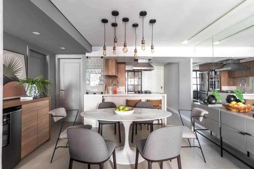 Detalhes metálicos, tons de cinza e madeira compõem apê elegante de 75 m²