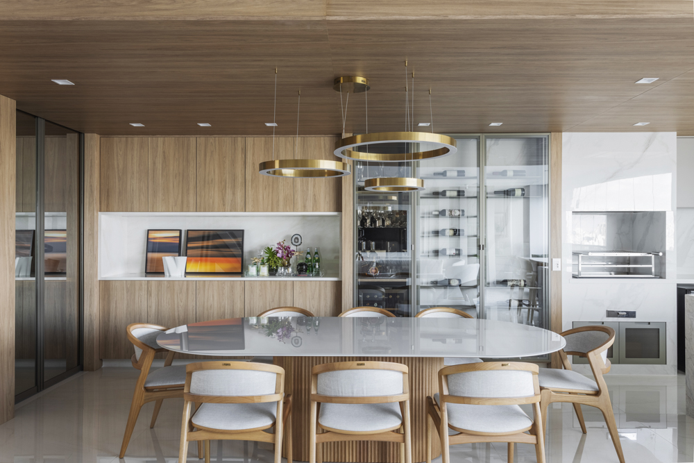 Poltronas giratórias e um banco clean se combinam para criar sala elegante em apê. Projeto de Daiane Antinolfi.