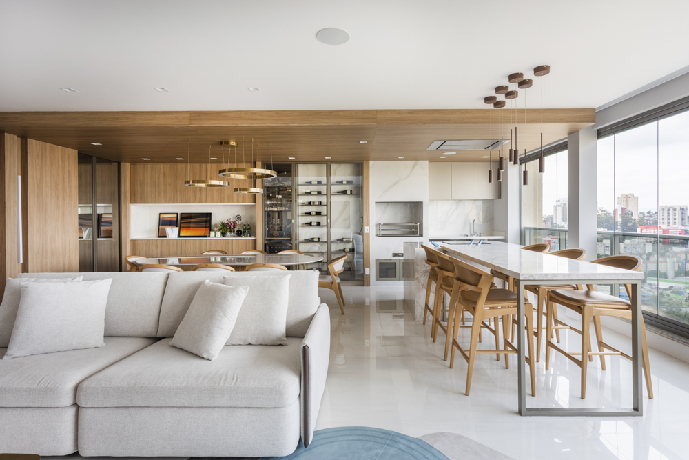 Poltronas giratórias e um banco clean se combinam para criar sala elegante em apê. Projeto de Daiane Antinolfi.