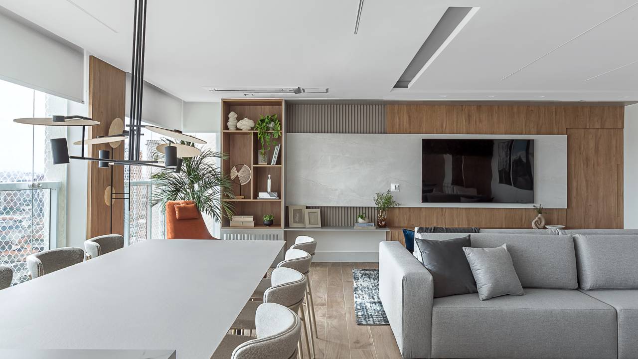 Reforma separa cozinha de estar e cria varanda gourmet com mesa de 3 m e 200 kg. Projeto de RMV Interiores.