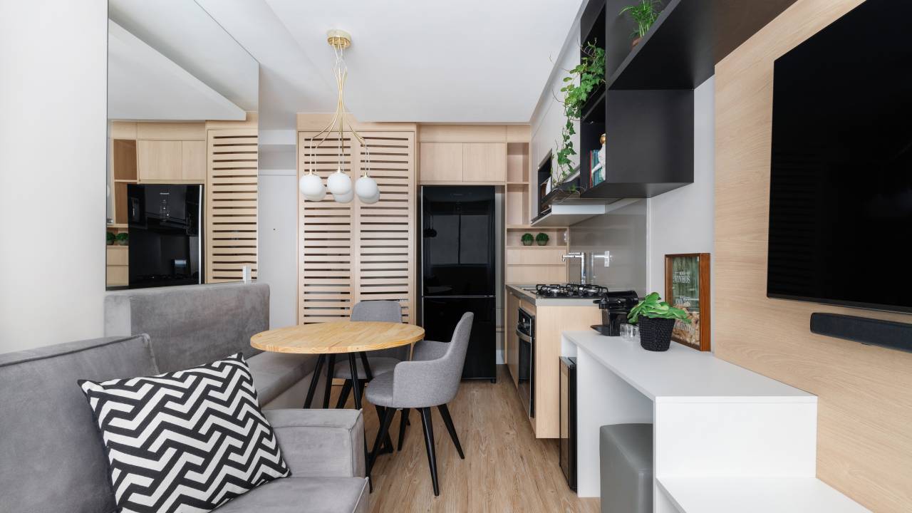 Apartamento compacto de 29 m² tem cozinha preta e branca cheia de estilo. Projeto de RMV Interiores.