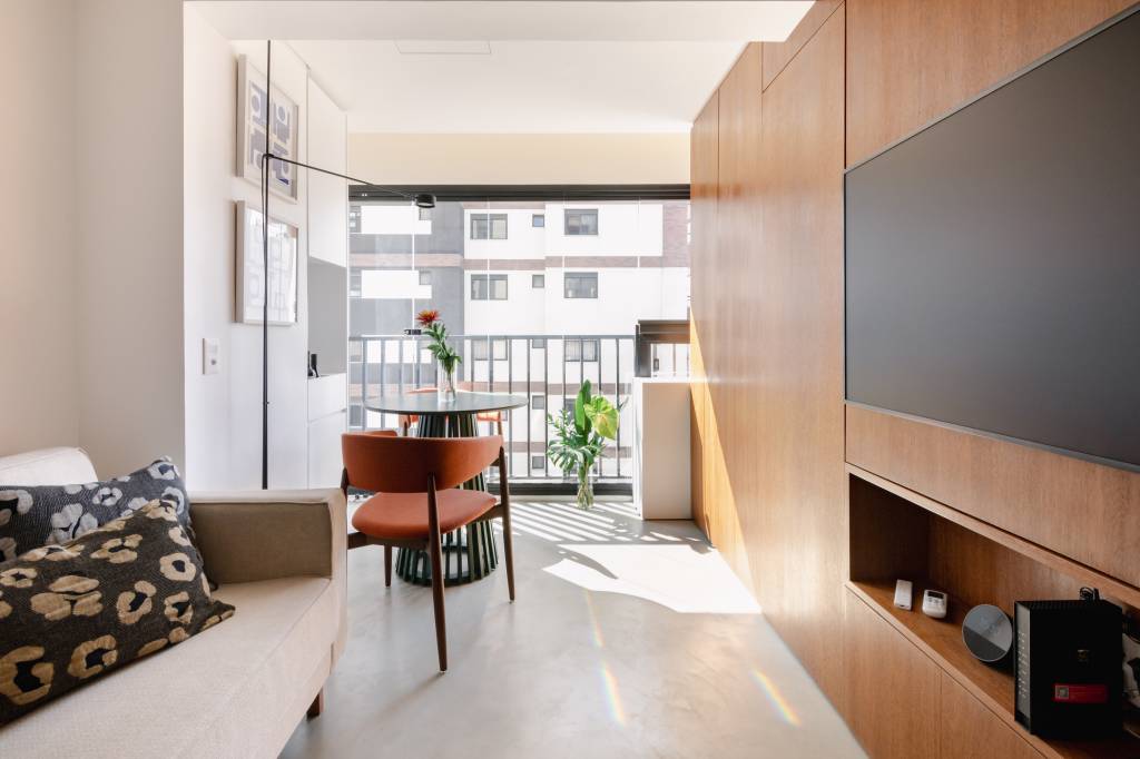 Apê pequeno tem home office verde e estiloso oculto na marcenaria