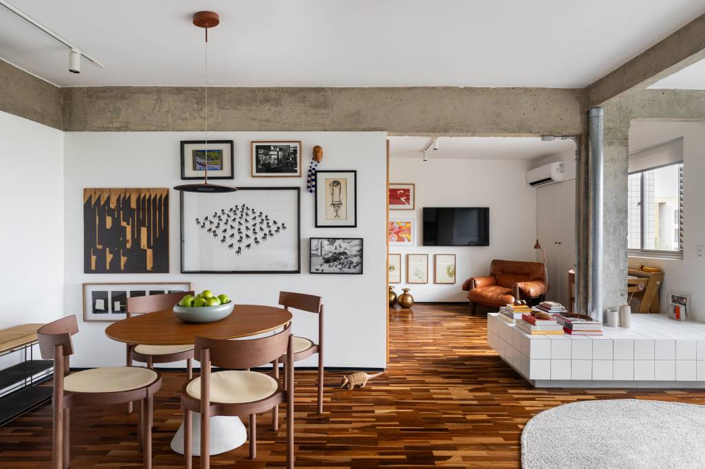 Apê tem piso de tacos reciclados e azulejos brancos pequenos na cozinha. Projeto de BLOCO Arquitetos.