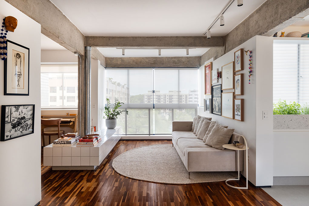 Apê tem piso de tacos reciclados e azulejos brancos pequenos na cozinha. Projeto de BLOCO Arquitetos.
