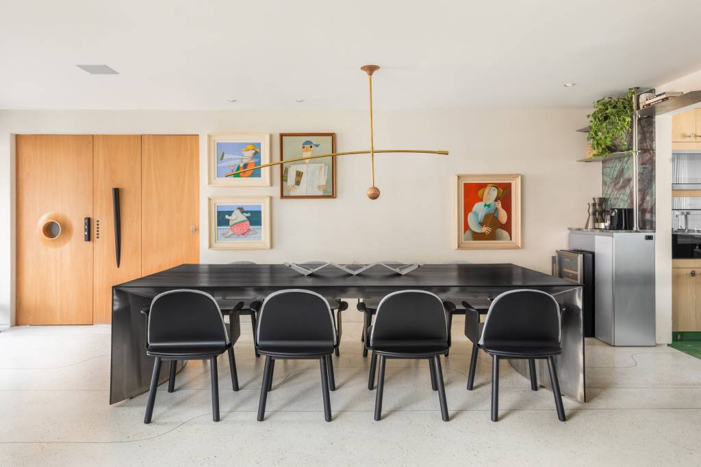 Estante em aço inox é peça que cria continuidade em área social de apê integrado. Projeto de Zalc Arquitetura.