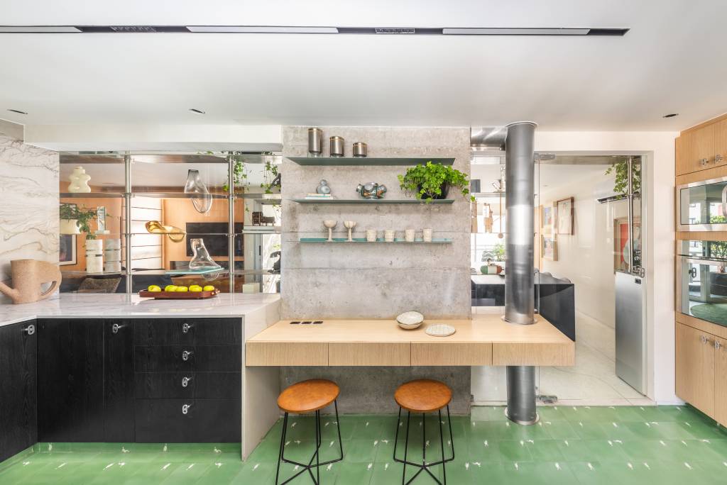 Estante em aço inox é peça que cria continuidade em área social de apê integrado. Projeto de Zalc Arquitetura.