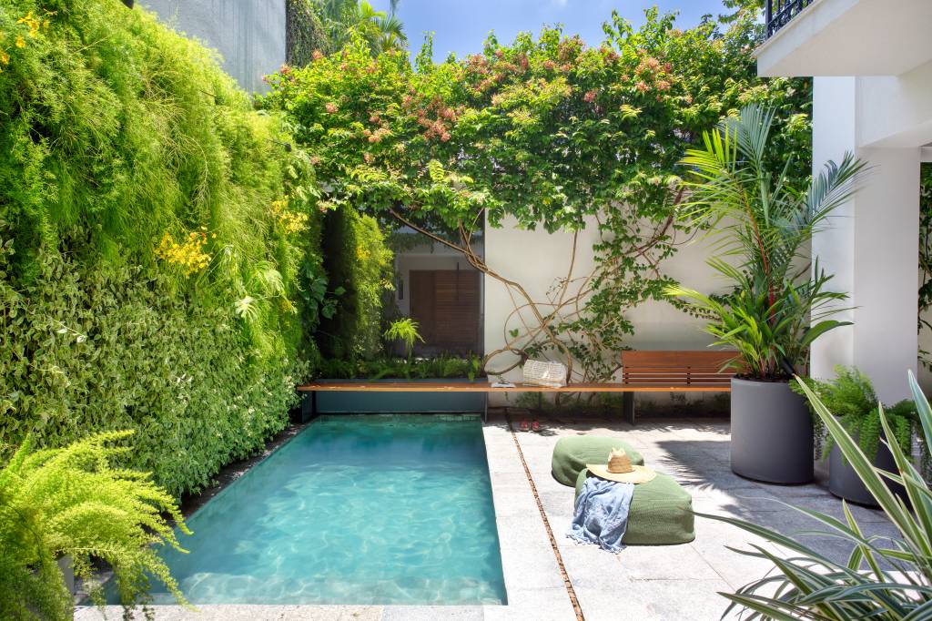 Jardins verticais criam portal verde e cercam piscina desta casa