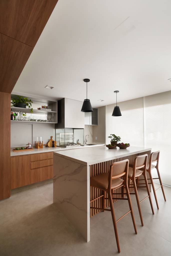 Passa-pratos garante fácil integração entre cozinha e varanda deste apê. Projeto de Rosangela Pena.