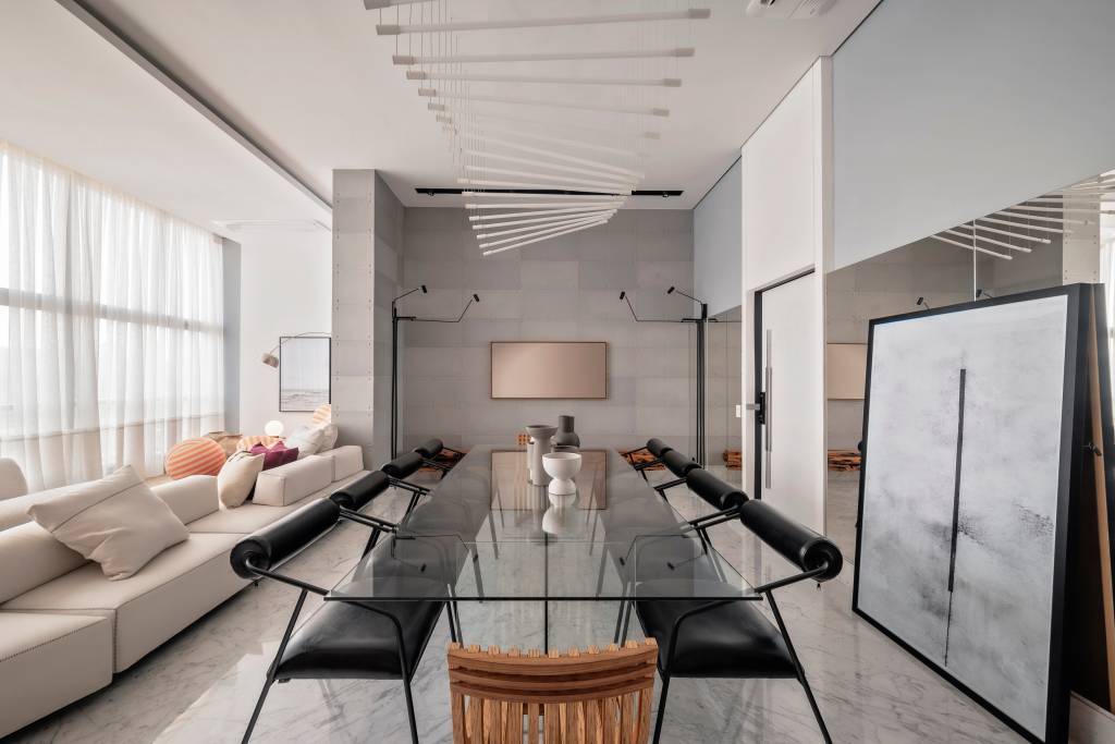 Apartamento dúplex de tem piso de mármore e parede envidraçada. Projeto de Karina Passarelli Arquitetura.