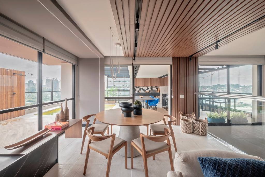 Apartamento dúplex de tem piso de mármore e parede envidraçada. Projeto de Karina Passarelli Arquitetura.