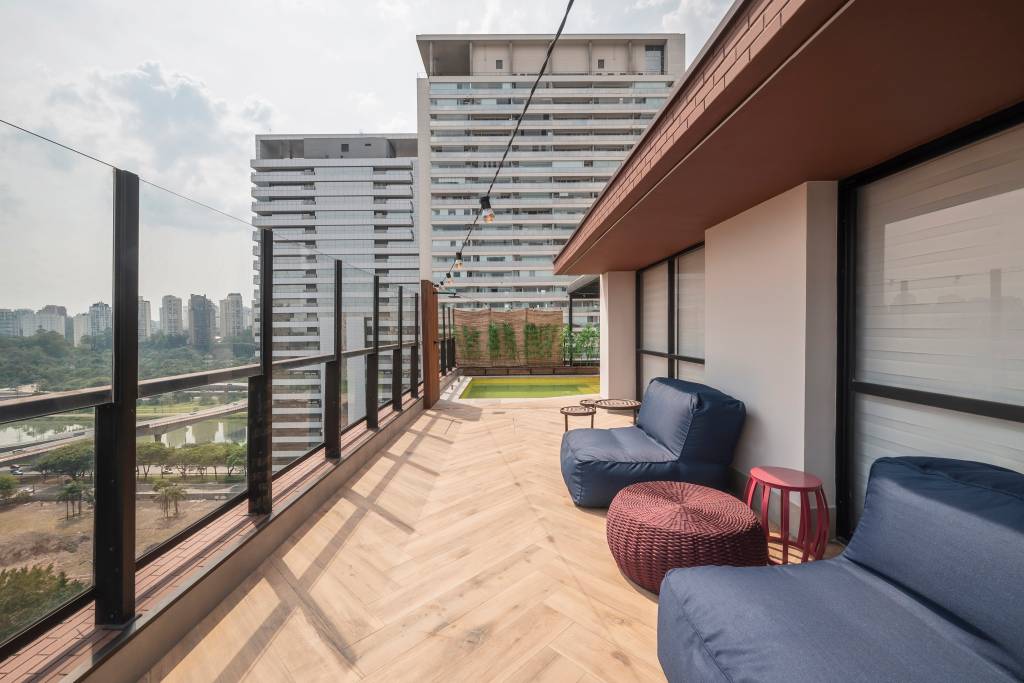 Apartamento dúplex de tem piso de mármore e parede envidraçada. Projeto de Karina Passarelli Arquitetura.
