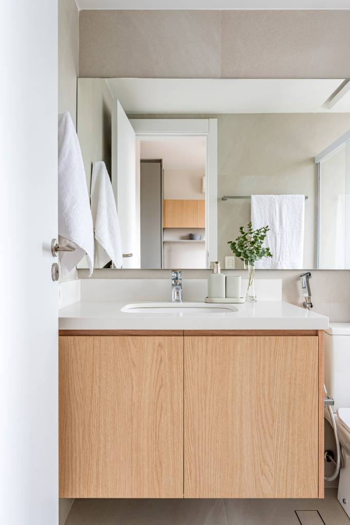 Tons de rosa seco, terroso e escuro compõem apartamento integrado. Projeto de Paula Müller.