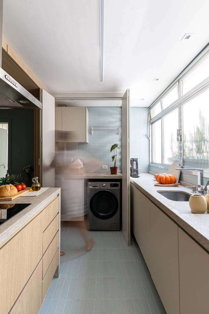 Apê de 65 m² tem lavanderia escondida na cozinha e mesa de bolachas. Projeto de Bianca Marques.