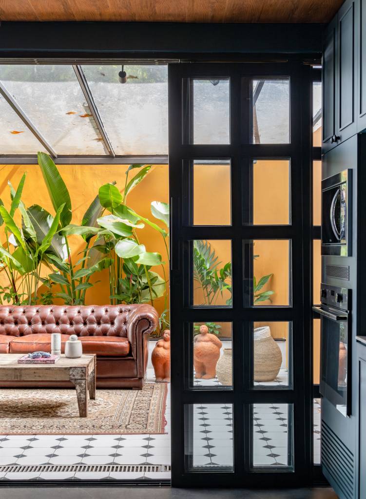 Cozinha azul é mix de moderno e provençal e fica integrada com quintal. Projeto de Casa Tauari.