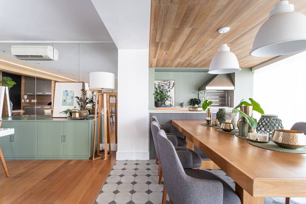 Detalhes verdes e piso de ladrilho hidráulico dão charme à apartamento