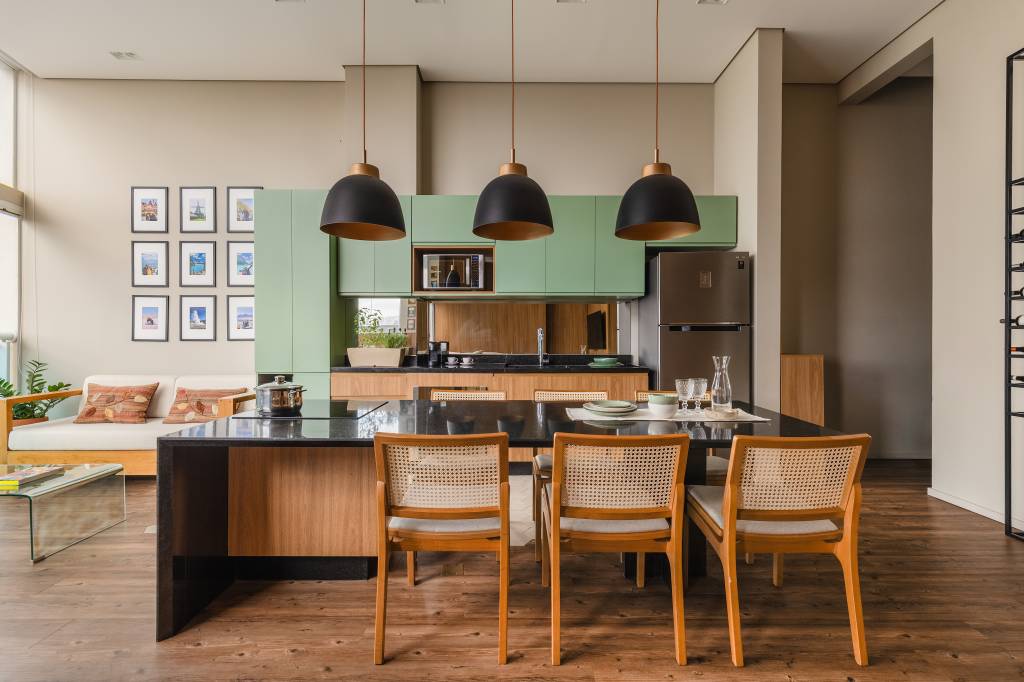 Estúdio tem mesa para seis pessoas, duas áreas de estar e lavanderia no lavabo