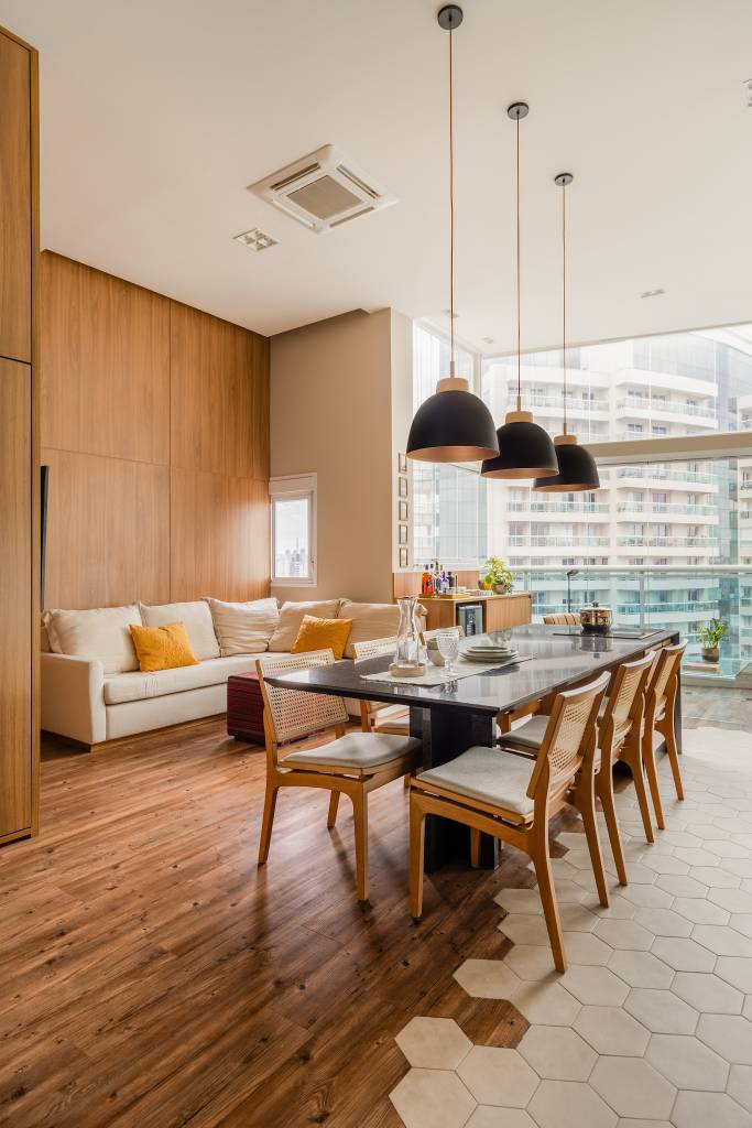 Estúdio tem mesa para seis pessoas, duas áreas de estar e lavanderia no lavabo. Projeto de STAL Arquitetura.