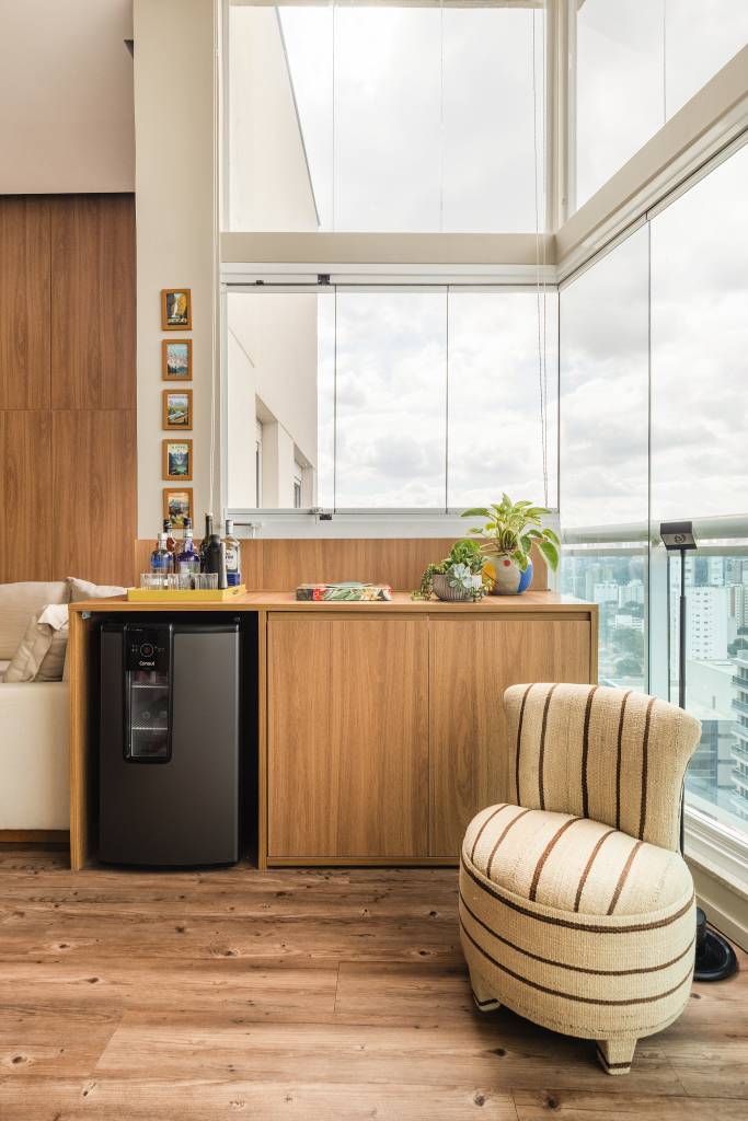 Estúdio tem mesa para seis pessoas, duas áreas de estar e lavanderia no lavabo. Projeto de STAL Arquitetura.