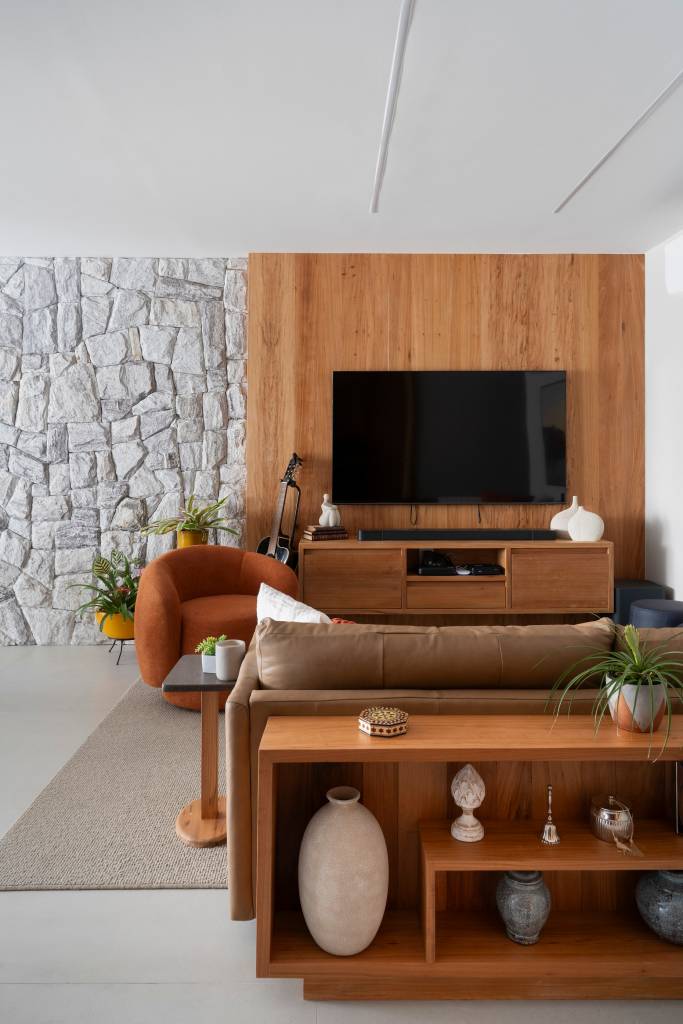 Parede de pedras na sala é ponto de partida deste apartamento elegante de 80 m². Projeto de Júlia Santana.