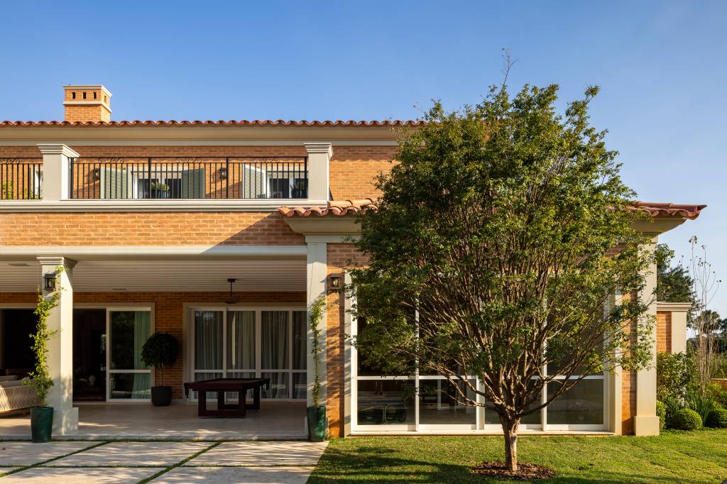 Tijolinhos, telhas de barro, madeira e mármore compõem casa em estilo toscano